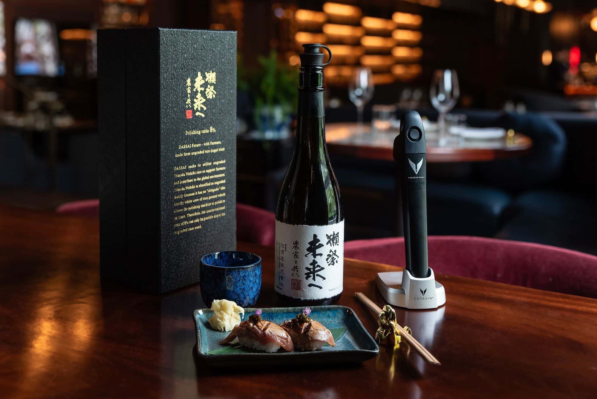 Premium Dassai sake paired with sushi nigiri, served in a modern fine-dining setting with a Coravin Pivot preservation system displayed alongside.